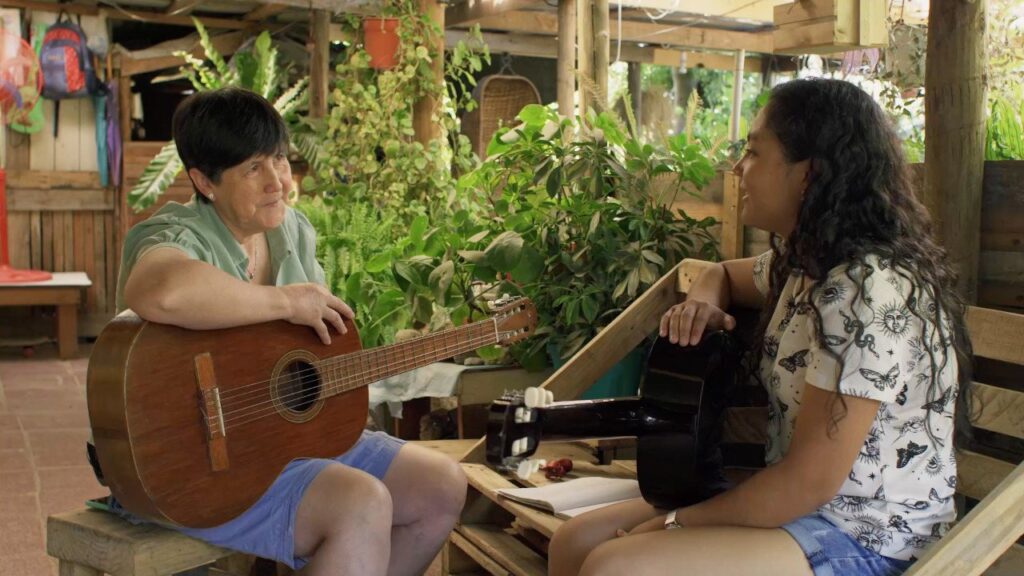 Mauricia le hace clases de guitarra a una adolescente de la localidad.